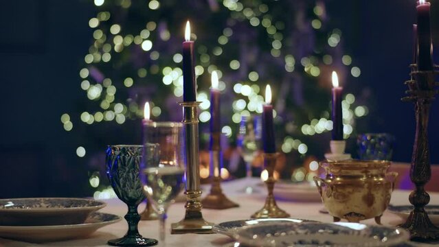 Video details very closeup of a beautiful Christmas dining table in the dining room with amazing Christmas tree taking video closeup capturing the candles and table decorations
