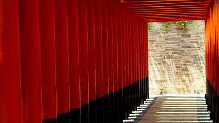 Ornaments on the Sam Poo Kong Pagoda in Semarang, a building lined with red pillars and black lines interspersed with reflections of sunlight.no people