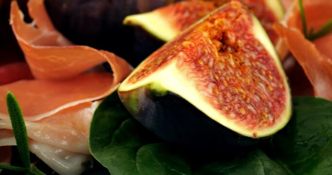 Figs, jamon, spinach leaves and blue cheeses on a wooden board. Snacks set.