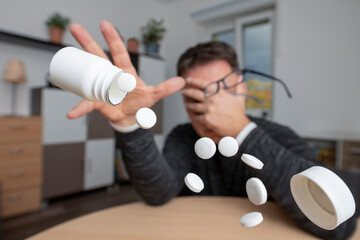 A man with health problems takes medication. Self-treatment and possible consequences.