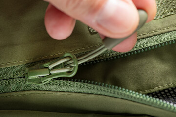 close-up zipper lock on green clothes.