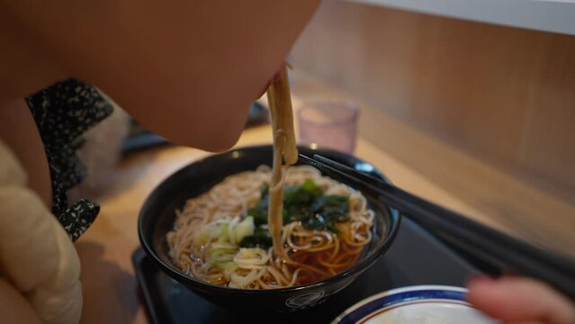 A women enjoy eating Japanese ramen, noodle. Woman using chopsticks eating Japanese ramen. Woman eating Japanese soba noodle soup. Japanese traditional food
