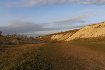 A grassy field with a hill in the background