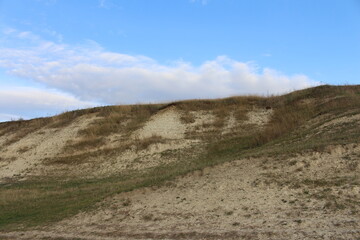 A grassy hill with a hill in the background