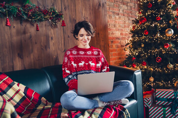 Photo of pretty young girl sit sofa working remotely netbook wear trendy red sweater festive...