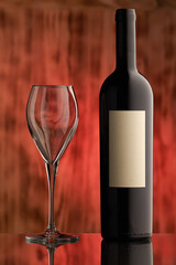 Wine bottle with white blank label and glass on black wooden rustic background with copy space. Nobody.