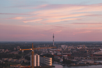 Aerial view of nightlife in the modern city of Rotterdam in the Netherlands. Red glow from the setting sun in the background