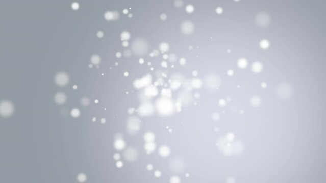 A blurry snowflake descends amidst a gray backdrop, conveying a wintry ambience with its motion, evoking a sense of coldness