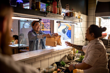 Young man picking up takeout from a sushi restaurant