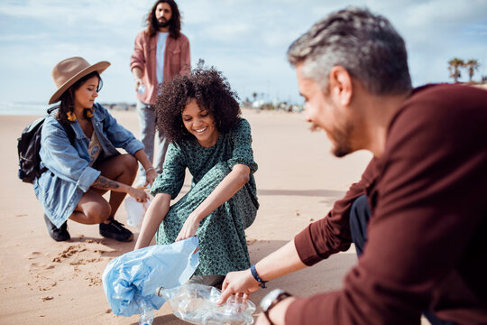Group of activists friends collecting plastic waste on the beach