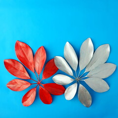 Christmas decoration. Red and silver leaves on a blue background. Summer concept. Flat lay, top view, copy space.	