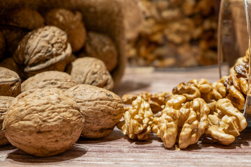 Peeled and whole walnuts coming out of a sack on a table