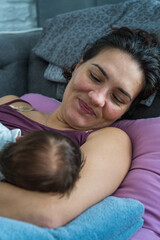 A loving mother takes care of her newborn baby. Mom breastfeeds her newborn baby. Breast-feeding.