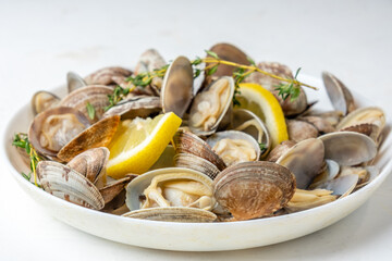 Plate with cooked vongole with lemon and herbs, close-up, selective focus.