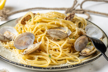 Pasta with shellfish in a plate, light background, close-up