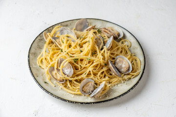 pasta with vongole clams and parmesan in a plate, light background.