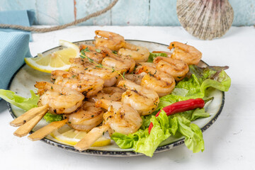 plate of shrimp skewers, fried shrimp served with lettuce and lime. Shrimp appetizer.