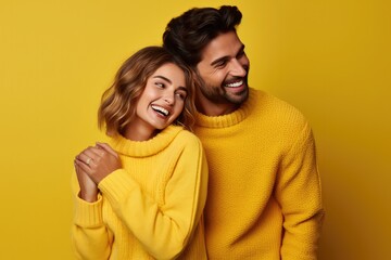 Fototapeta premium Happy young couple in love, smiling with joy, enjoying romantic relationship on yellow background.