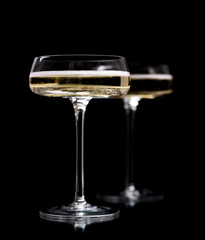 Two champagne glasses on a black