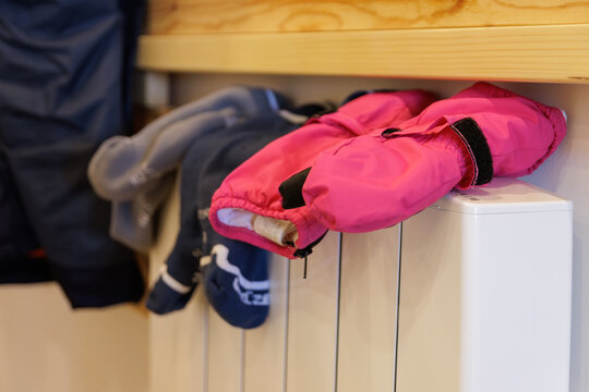 Gloves and socks used in the snow and wet, on the home heating radiator drying