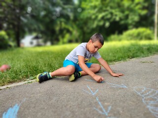 a boy is playing with chalk in the park