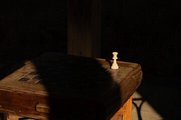 Queen chess piece on an outdoor board by itself
