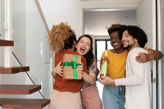 Friends welcoming couple at home - Powered by Adobe