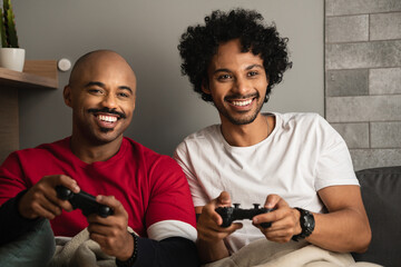 Young couple have fun playing video games in the living room at home