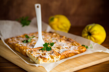 prepared curd semolina pie with quince inside and covered with powdered sugar .