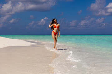 Fototapeta na wymiar Young dreadlocks woman in bikini poses against sea background