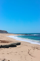 View over the Atlantic Ocean from shore. Portugal. Large beach with huge stone.