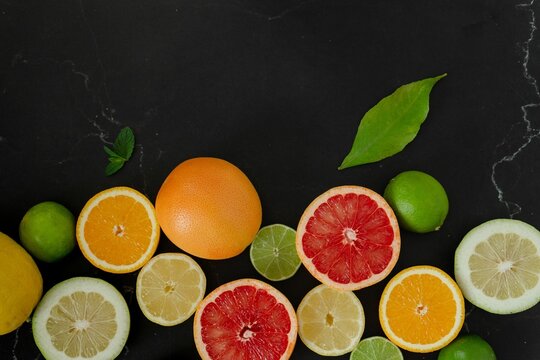 Vibrant and juicy close-up shot of citrus fruit slices, including grapefruit, oranges, and lemons © Wirestock