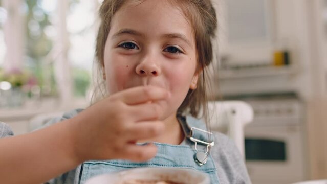 Marshmallow, eating and face of a girl with ice cream, sweet food and licking fingers in enjoyment. Smile, happy and portrait of a child with dessert for happiness, cheerful and enjoying in kitchen