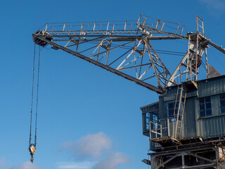 Fototapeta na wymiar Old nostalgic port wooden crane against the blue sky