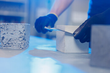 Engineer measures size and controls quality of concrete cube in laboratory. Concept industry lab...