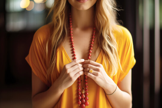 Young woman, yoga teacher holding a mala beads yoga necklace