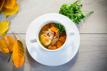 Autumn soup with chicken, noodles and autumn vegetables in a bowl .