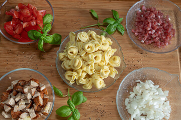 Onion, bacon, minced meat and tortellini are the ingredients for a tortelini salad