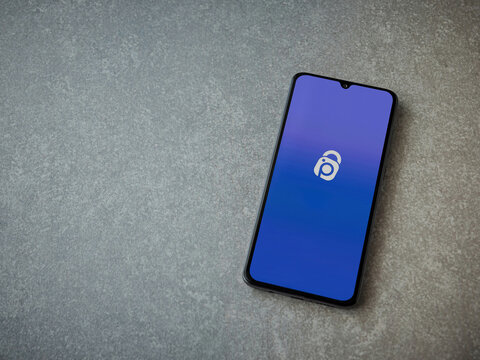 Lod, Israel - July 16,2023: IDrive Photo Backup app launch screen on smartphone on ceramic stone background. Top view flat lay with copy space.