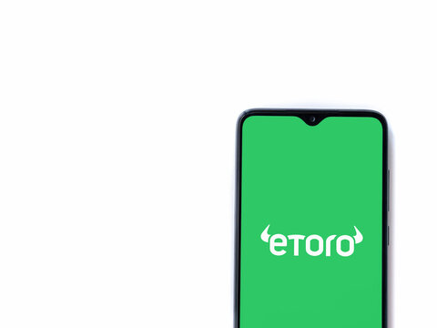 Lod, Israel - July 16,2023: eToro app launch screen on smartphone on white background. Top view flat lay with copy space.