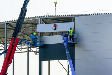 Sandwich panels wall assembly using telescopic boom crane and two self propelled articulating lifts © Zigmunds
