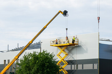Sandwich panels wall assembly using telescopic boom crane and self propelled scissor lift platform © Zigmunds