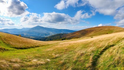 landscape with grassy meadows distant mountain beneath a sky with clouds beautiful panoramic scenery of carpathian countryside on a sunny day in early autumn