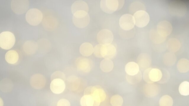 Abstract blurred glowing golden lights rotate in slow motion. Shining bokeh background. Christmas and New Year