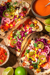 Mexican tradition recipes:  testy vegan Tacos, plant based diet,  with black beans, corn, jalopeno peppers, red cabbage, salsa, coriander leaves and marinated onion. Top view