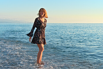 Teenage girl in a dress against the backdrop of a seascape