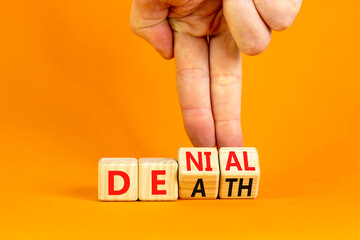 Denial death symbol. Concept words Denial Death on wooden block. Beautiful orange table orange background. Businessman hand. Business denial death concept. Copy space.