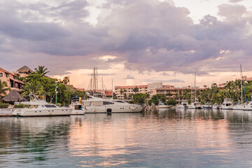 Luxury yachts docked in sea port at colorful sunset. Marine parking of modern motor boats