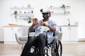 Close u of delighted african male in wheelchair with VR headset while staying in good mood on sunny...