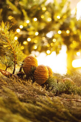 Christmas decor made from natural materials. Fir cones and branches against the background of sparkling garlands, soft selective focus